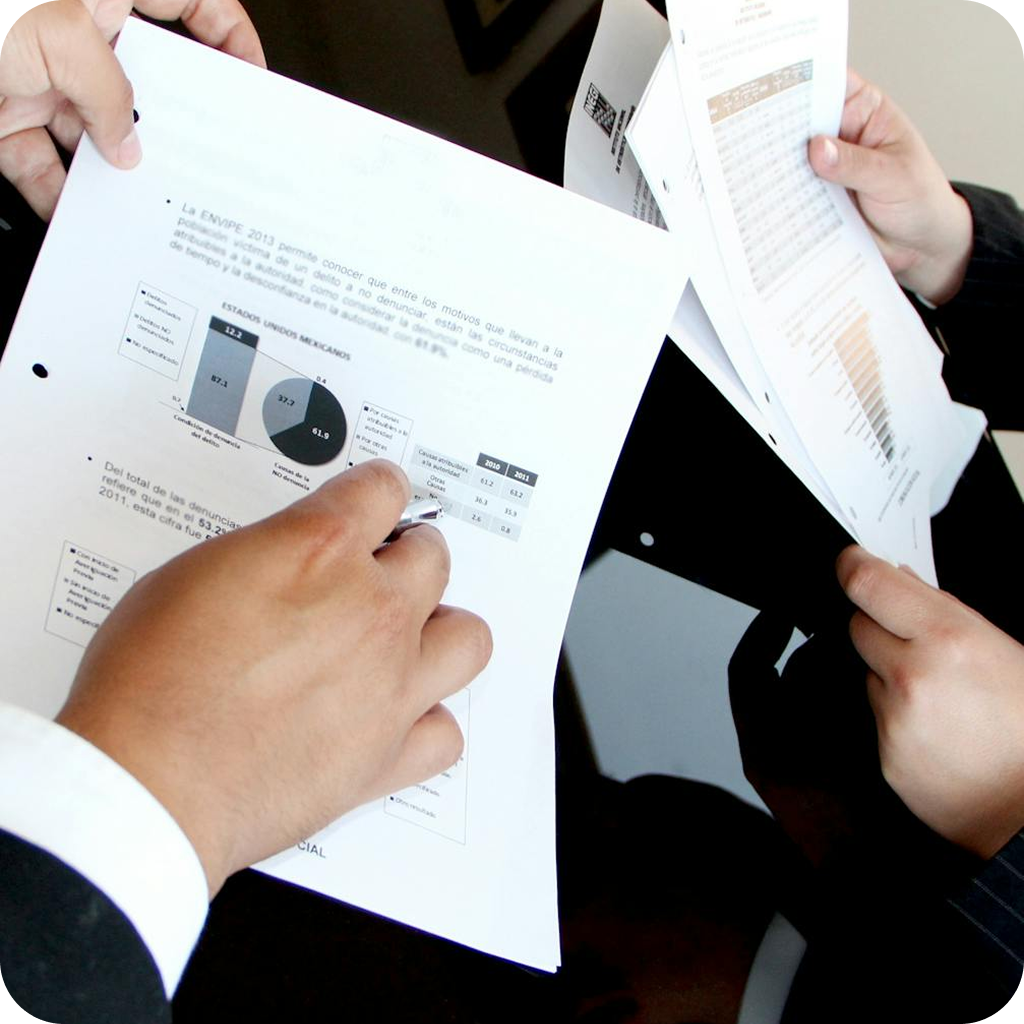 eam reviewing printed reports and SLA documents during post-launch project meeting